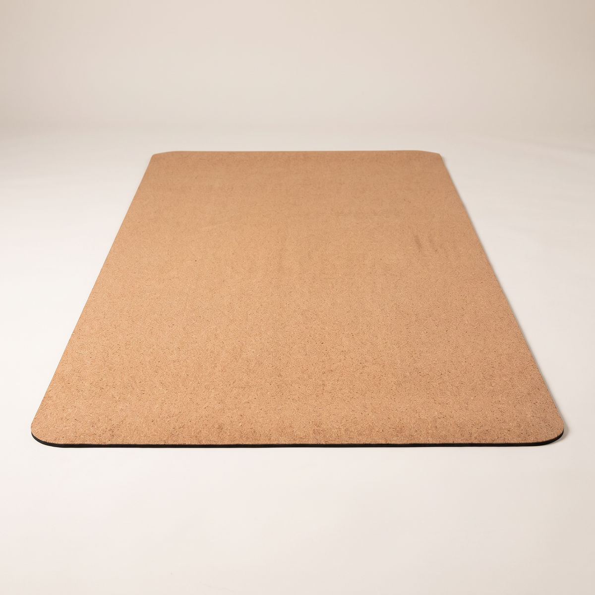 Non-slip cork yoga mat on clean white studio background