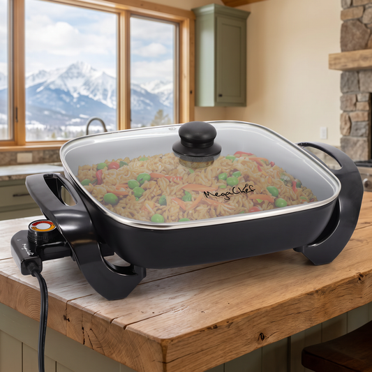 Electric Skillet with Non-Stick Coating and Glass Lid staged in a cozy mountain cabin kitchen with snow-capped mountain view