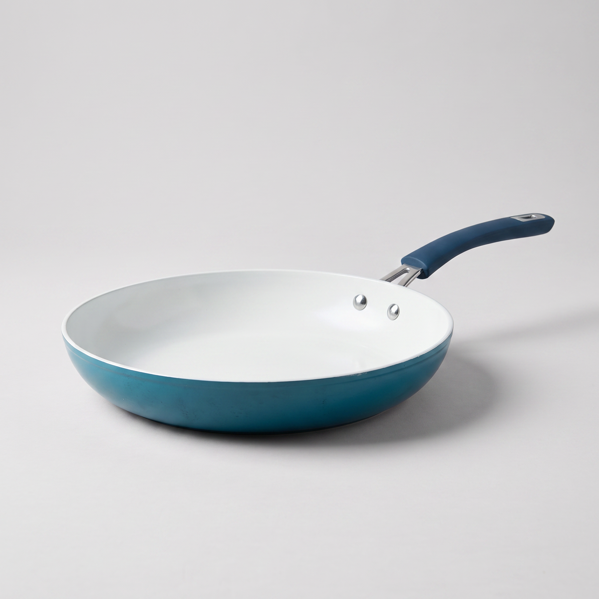 Oster Corbett 12-inch nonstick ceramic frying pan in blue, clean studio catalog product shot on neutral gray background